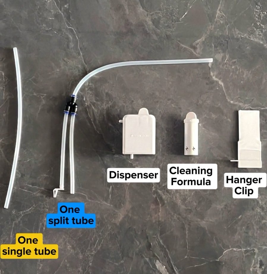 Everything laid out and labeled: one single tube, one split tube, the dispenser, the spare cleaning cartridge, the hanger clip