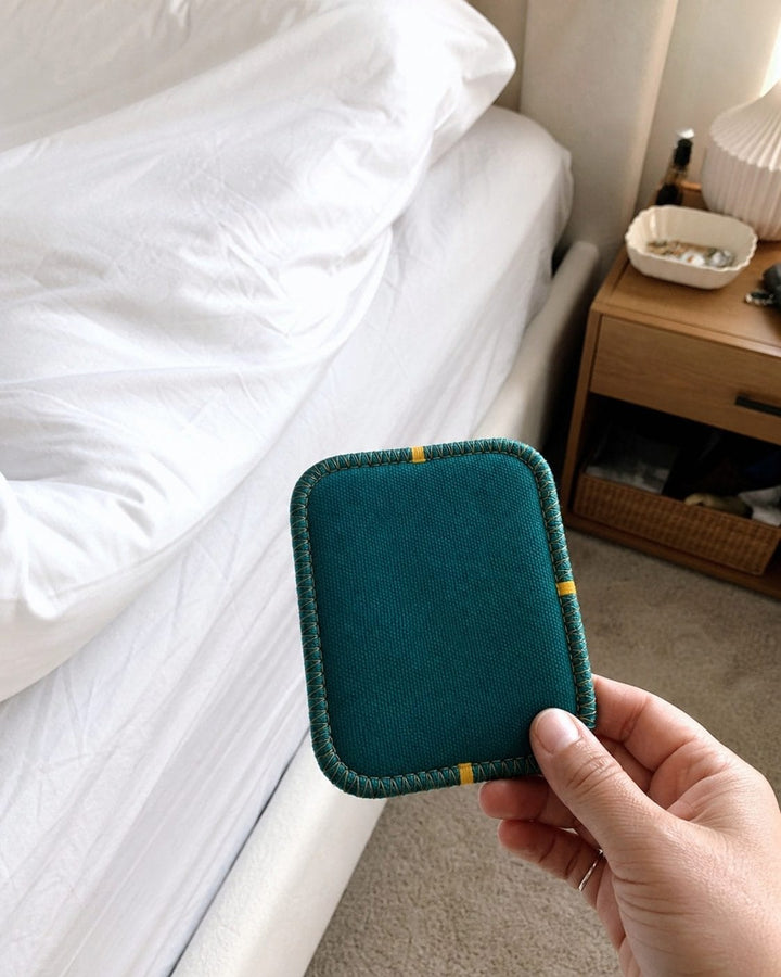 UGC customer photo holding a CaptureCard beside a bed
